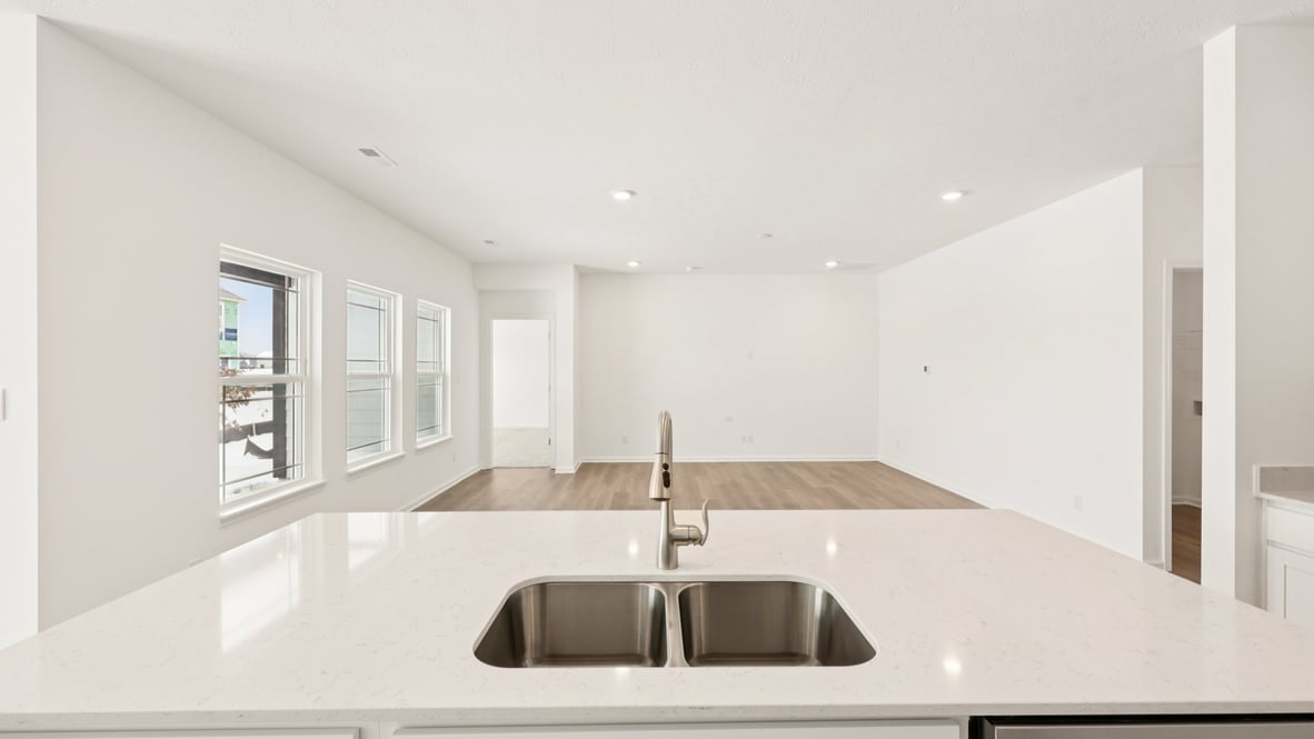 Kitchen island with sink view to dining, living areas adds seating, pantry, prep zones, perfect for everyday life