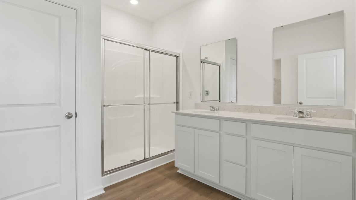 primary bathroom with dual vanity and walk-in shower