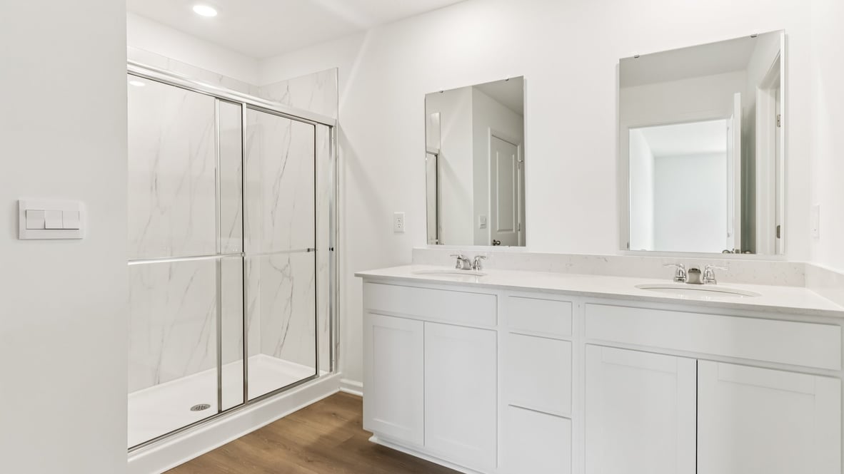 primary bathroom with dual vanity and walk-in shower