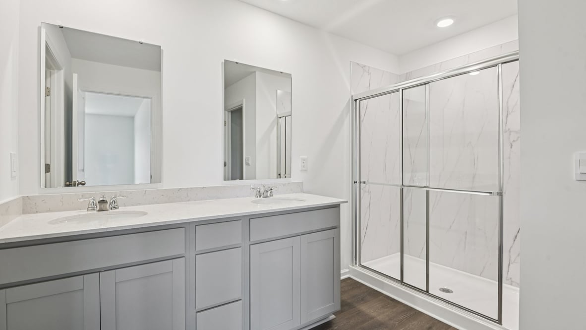 primary bathroom with dual vanity and walk-in shower