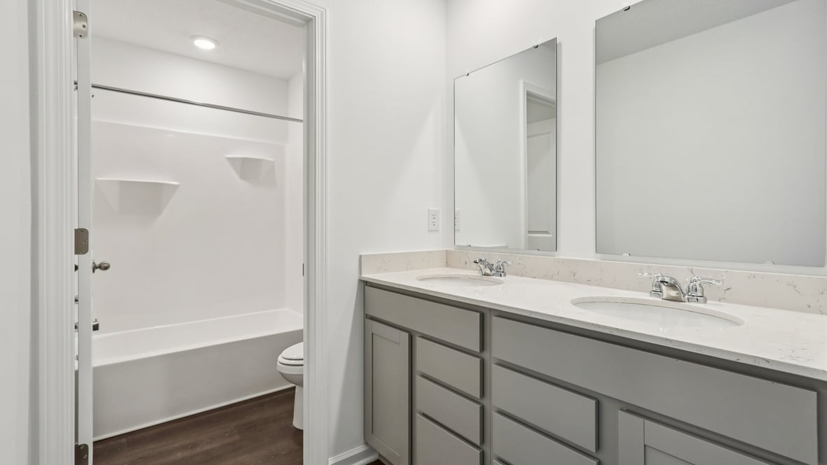 bathroom with dual vanity and walk-in shower