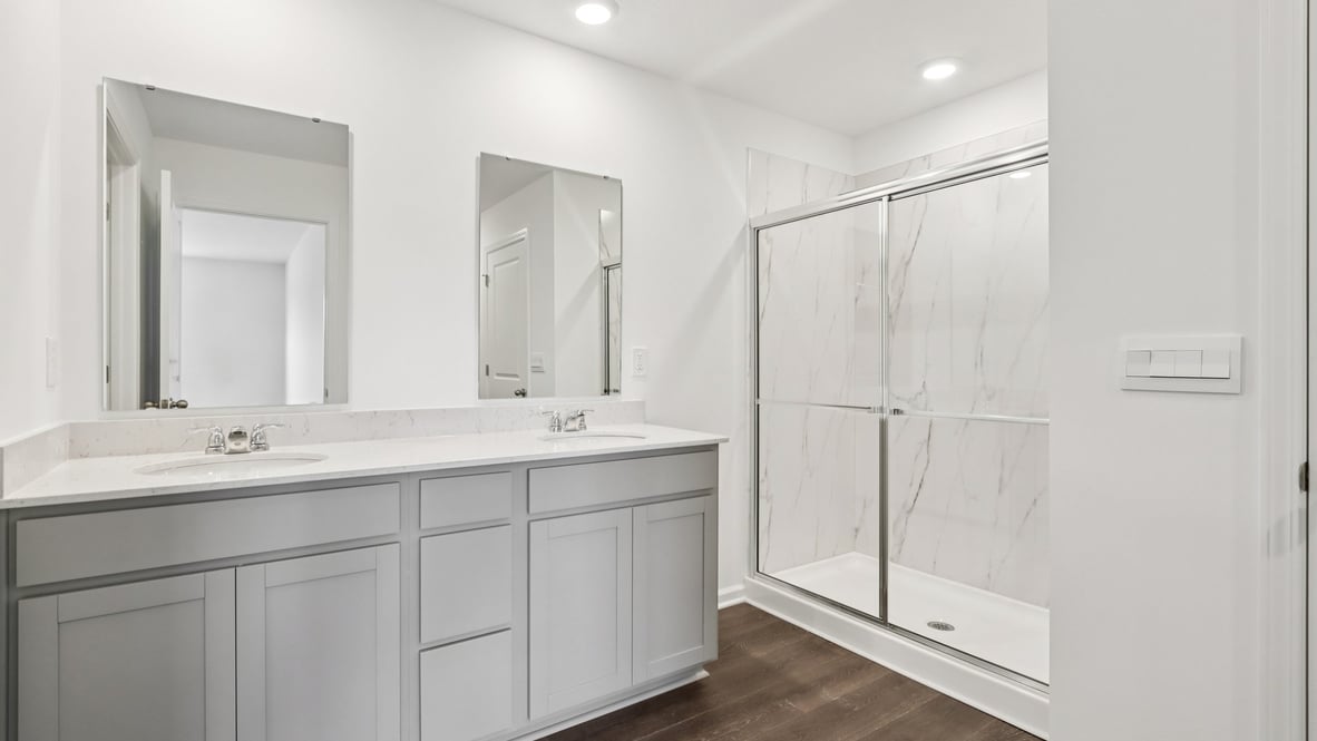 primary bathroom with dual vanity and walk-in shower