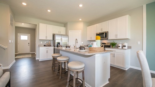 The kitchen offers beautiful cabinetry, quartz countertops, a large pantry and a built-in island with ample seating space.