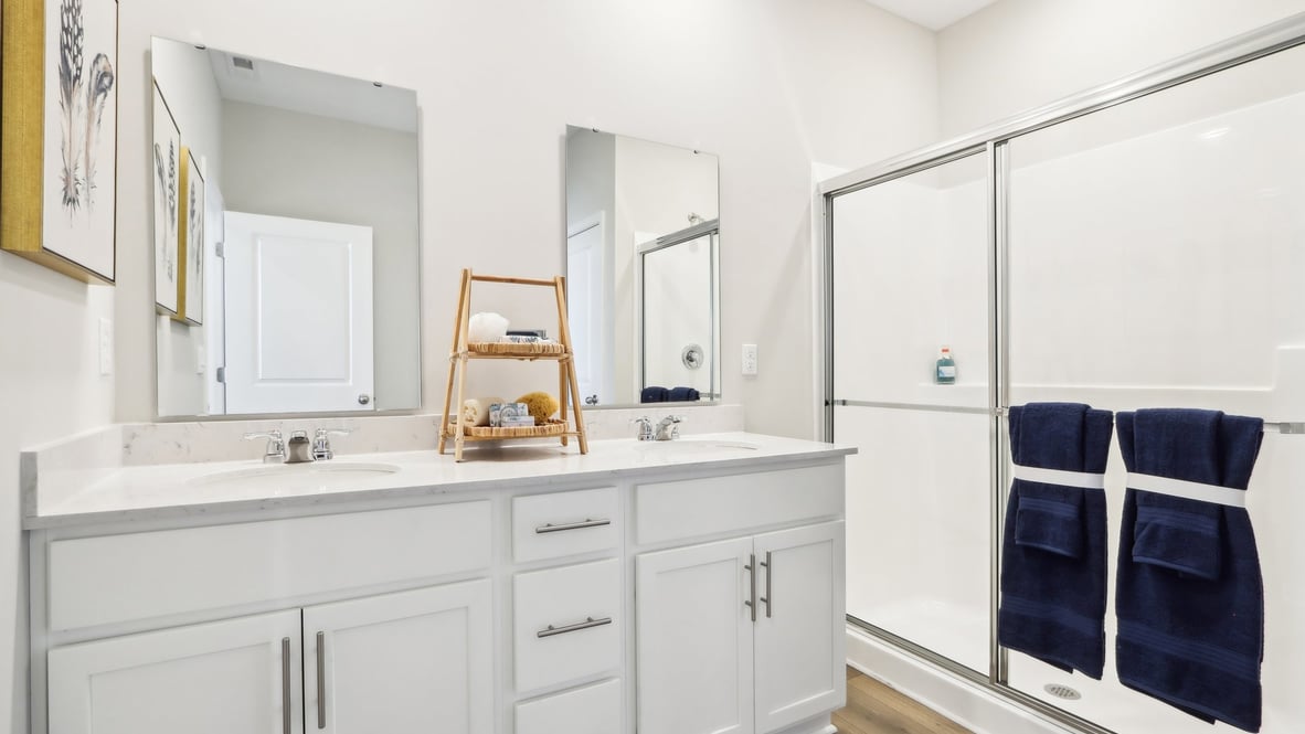 primary bathroom with dual vanity and walk-in shower