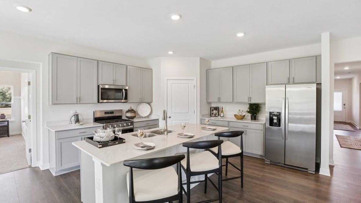 kitchen with white cabinets, island, pantry and stainless steel appliances