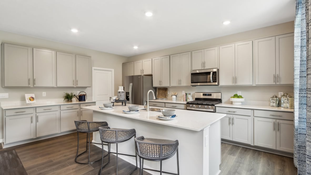 kitchen with white cabinets, island, pantry and stainless steel appliances