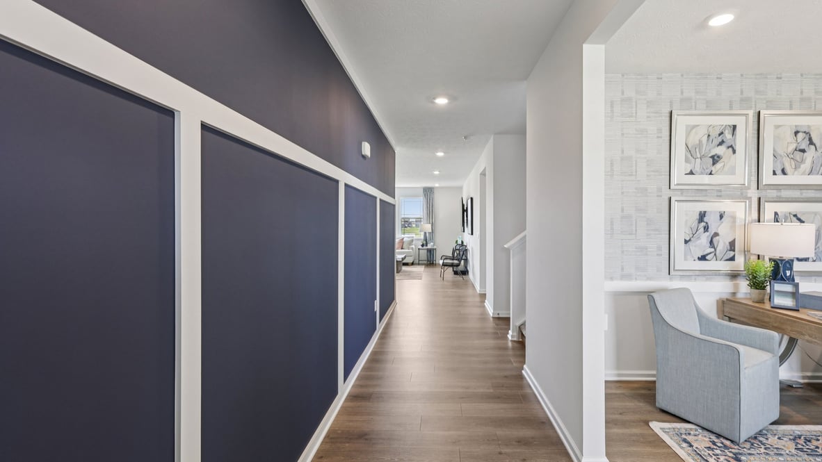front entry way of home featuring brown flooring and  a navy blue accent wall