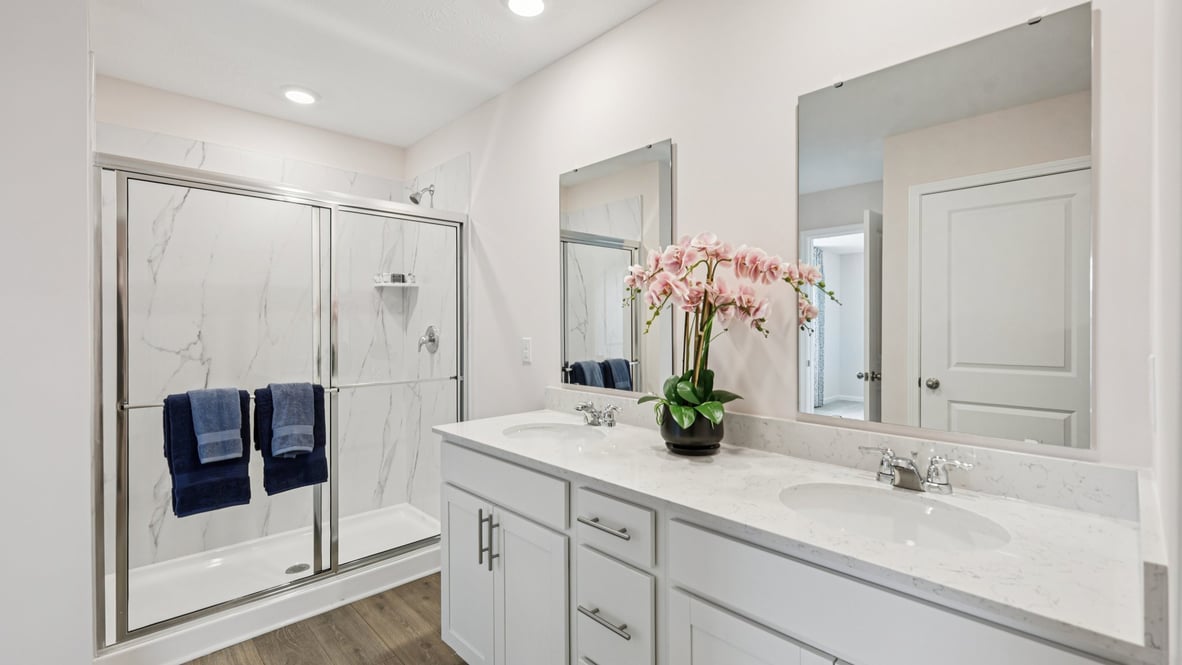 bathroom with dual vanity sinks, toilet, and a walk in shower