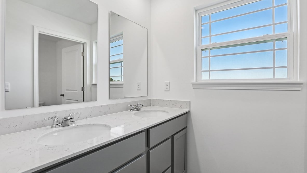 bathroom with gray cabinets and quartz counters