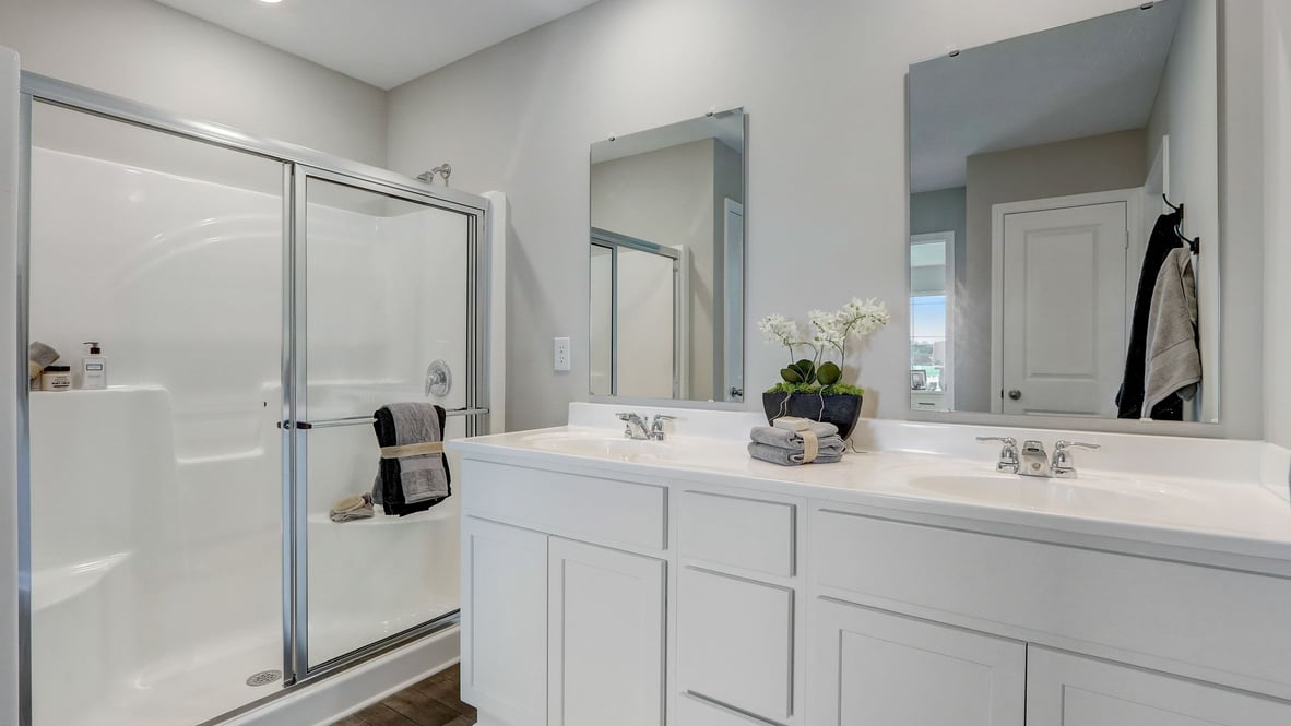 primary bathroom with dual vanity and walk-in shower