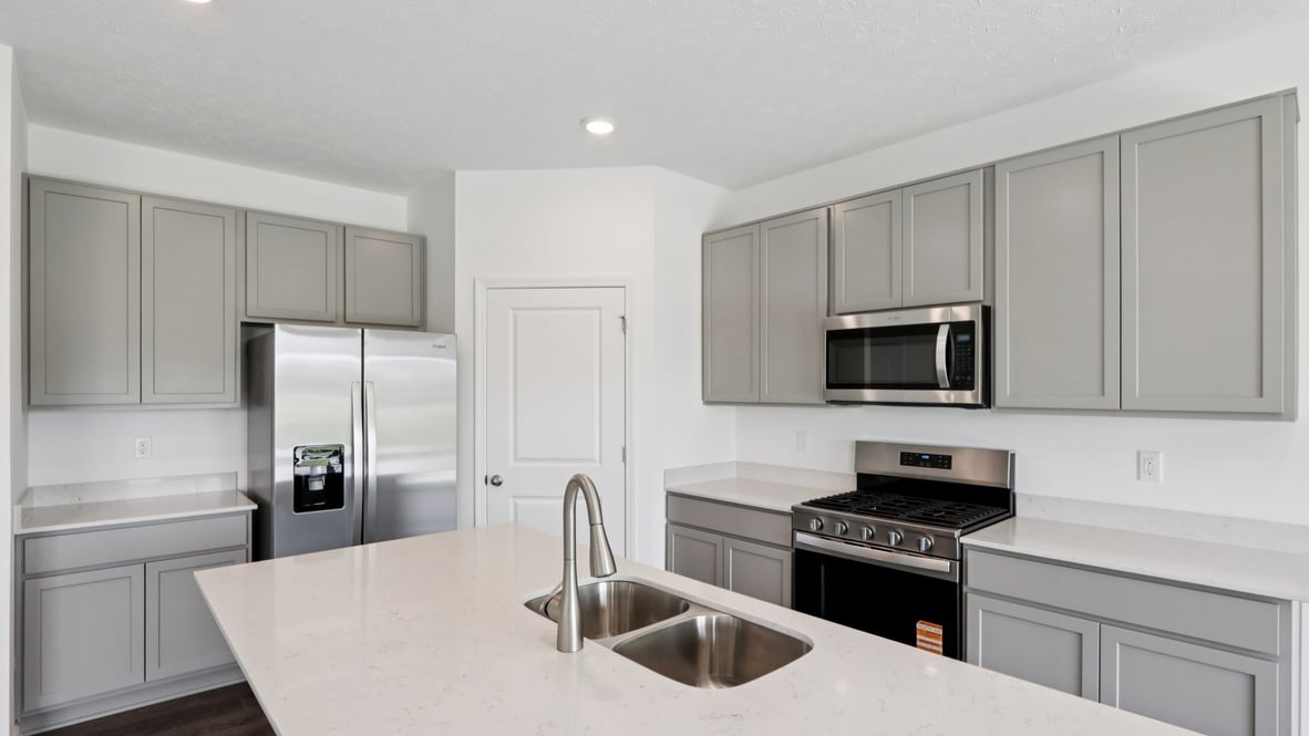 kitchen with light grey cabinetry, large island and stainless steel appliances