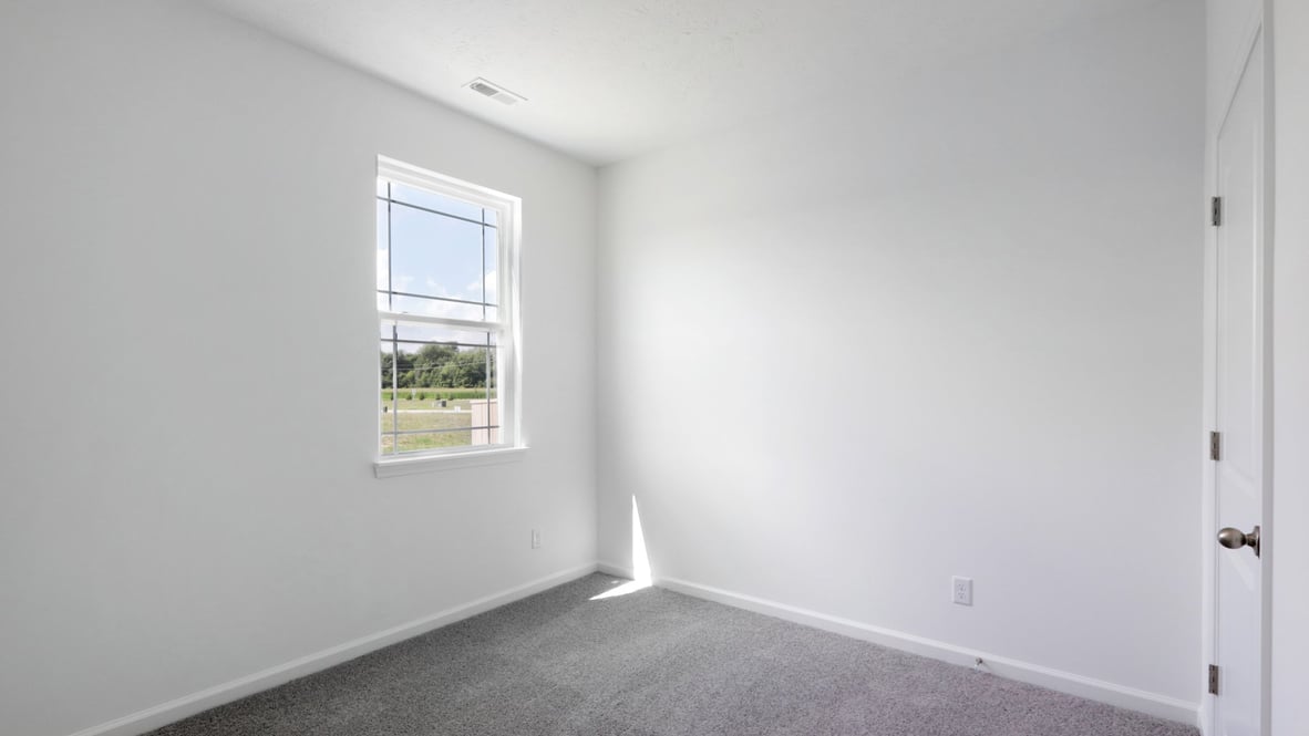 bedroom with grey carpet and white walls and a window