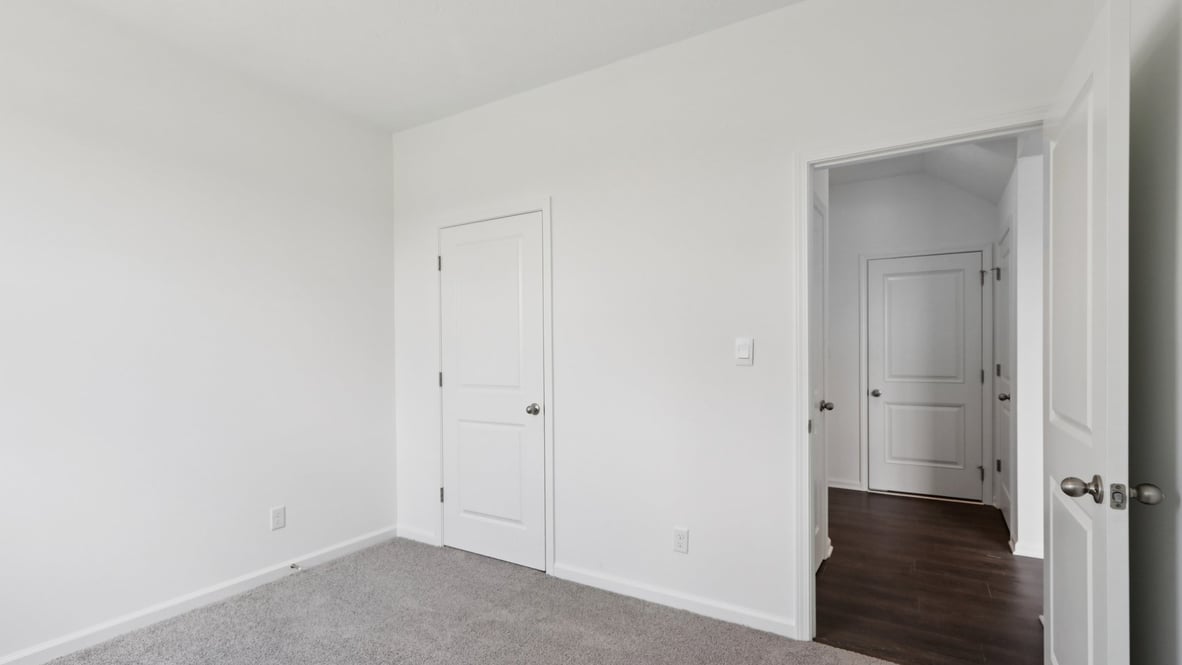 bedroom with grey carpet and white walls and a window