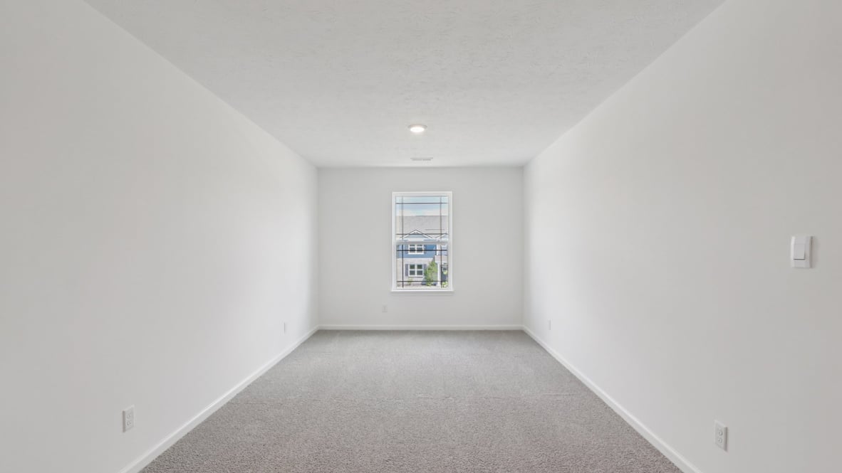 bedroom with grey carpet and white walls and a window