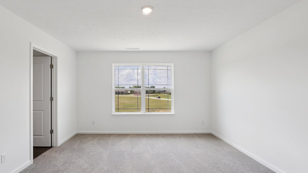 bedroom with grey carpet and white walls and a window