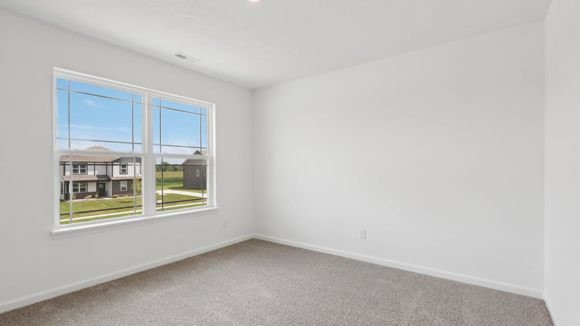 bedroom with grey carpet and white walls and a window