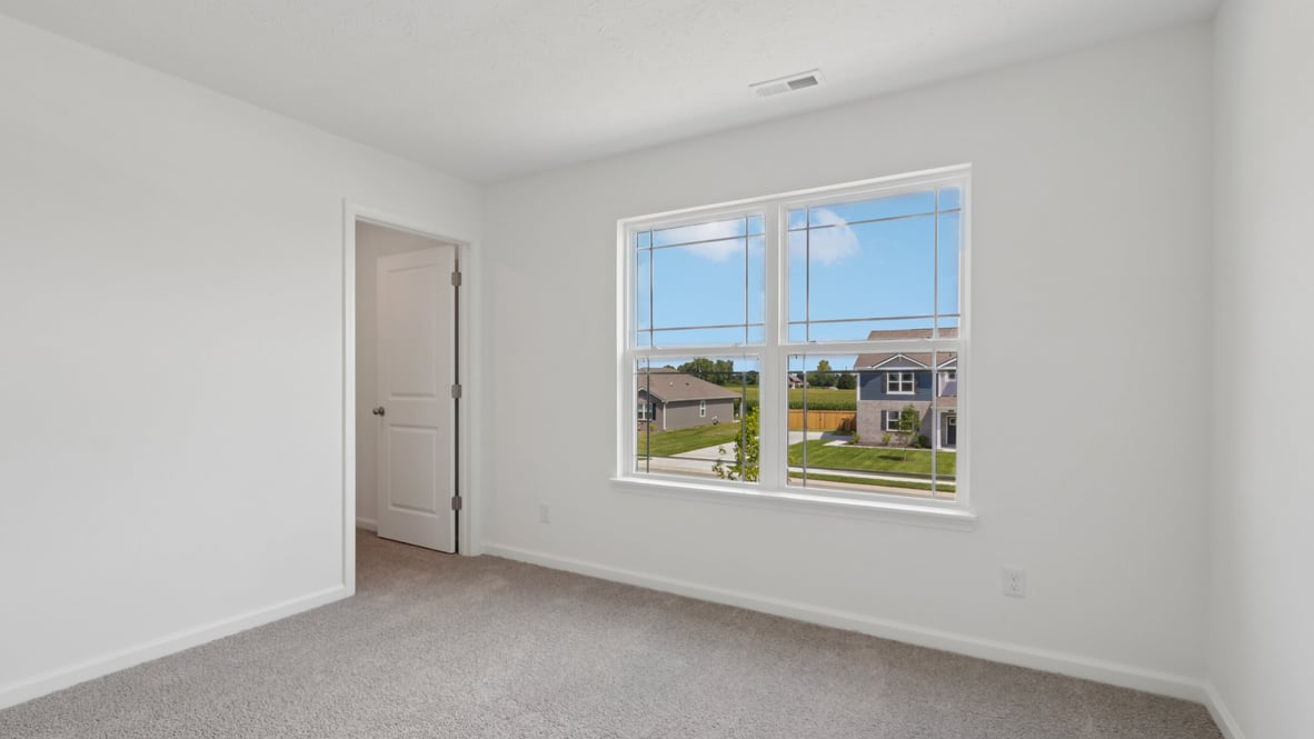 bedroom with grey carpet and white walls and a window