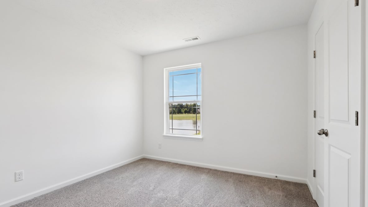 bedroom with grey carpet and white walls and a window