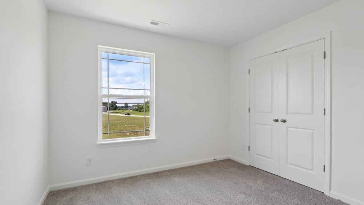 bedroom with grey carpet and white walls and a window