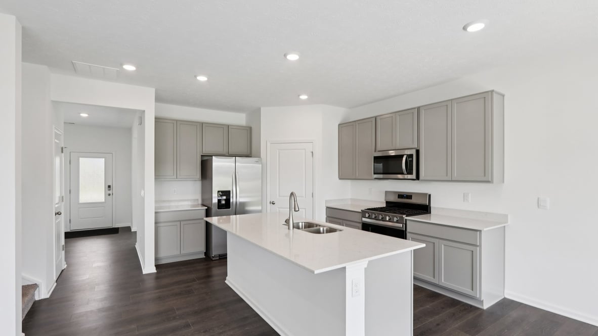 kitchen with light grey cabinetry, large island and stainless steel appliances