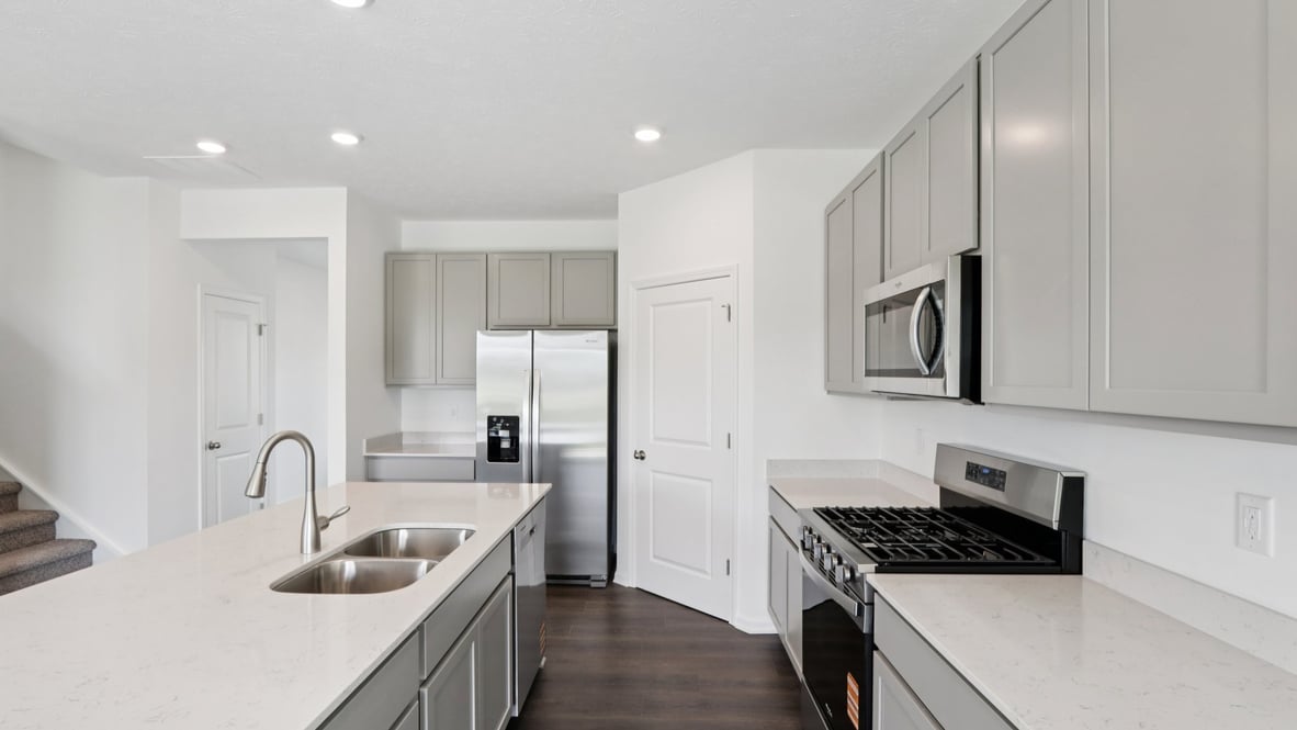 kitchen with light grey cabinetry, large island and stainless steel appliances