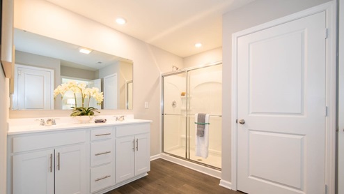 primary bathroom with dual vanity and walk-in shower