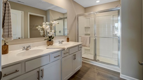 The primary bathroom includes a stand up shower, private commode and linen closet