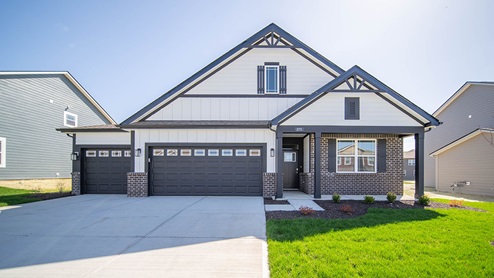 ranch home with 3 car garage showcasing dark trim and white board and batten