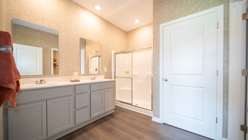 primary bathroom with dual vanity and walk-in shower