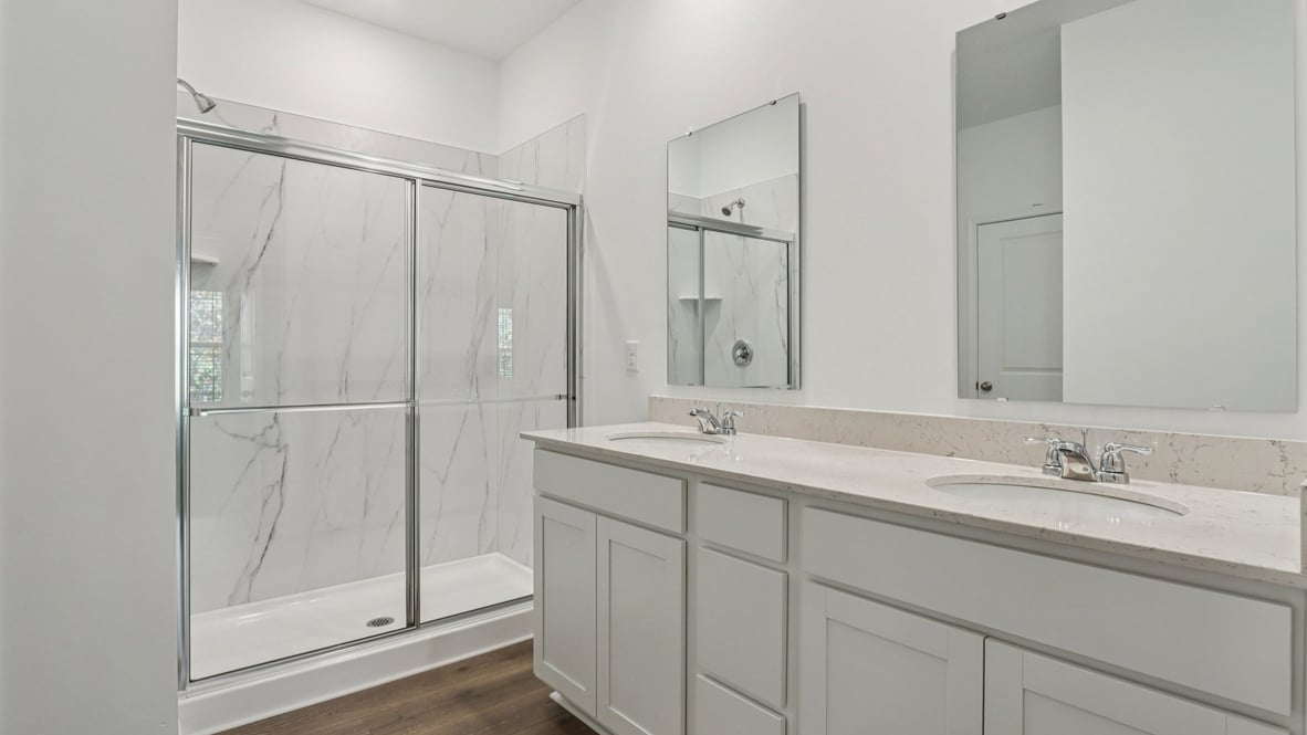primary bathroom with walk-in shower and dual vanity
