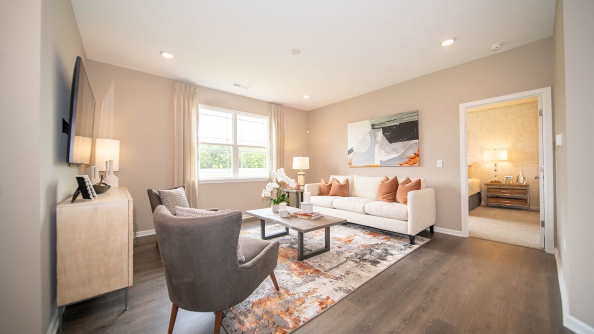 Great room with two windows and vinyl wood flooring.