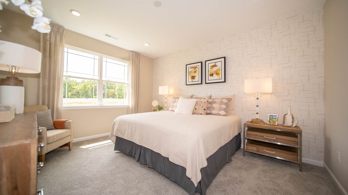 Pirmary bedroom with two windows and carpet flooring.