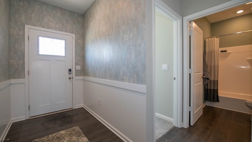 Welcoming entry to the Dennis, a spacious 2-story home features a highly desired main level primary bedroom suite.