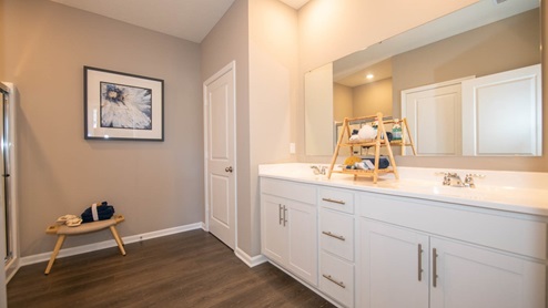 Bedroom 1, privately located in the rear of the home, is generously sized with a private bath that includes dual sinks, a private commode and a walk-in closet