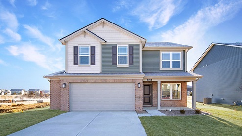 two story home with green and tan color scheme, brown brick