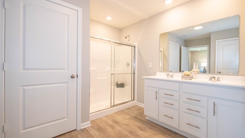 primary bathroom with dual vanity and walk-in shower