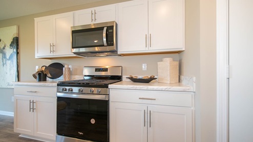 The kitchen offers beautiful cabinetry, a large pantry and a built-in island with ample seating space