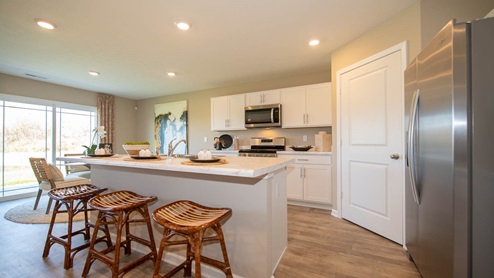 The kitchen offers beautiful cabinetry, a large pantry and a built-in island with ample seating space.