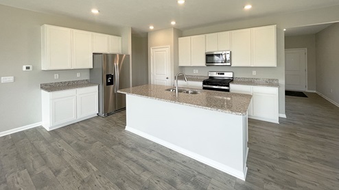 The kitchen offers quartz countertops, beautiful cabinets, an island for prepping or enjoying your favorite meals and stainless steel appliances.