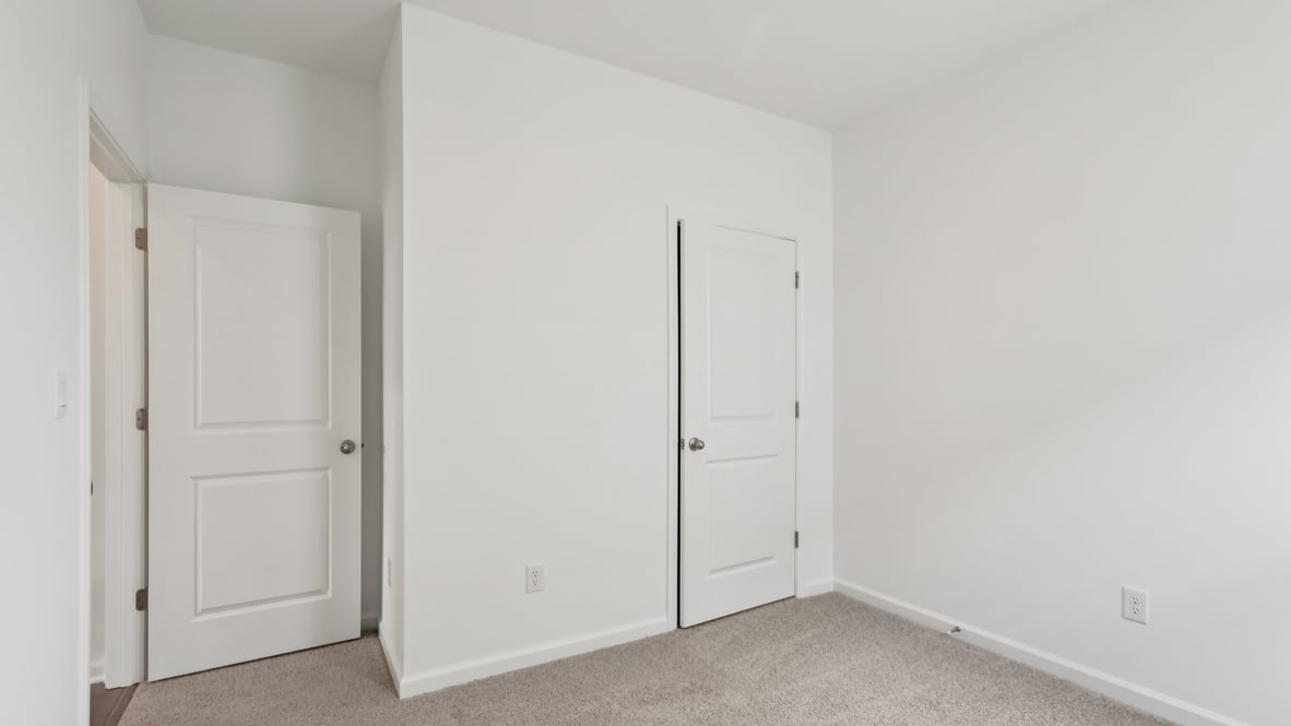 bedroom with brown flooring, white walls