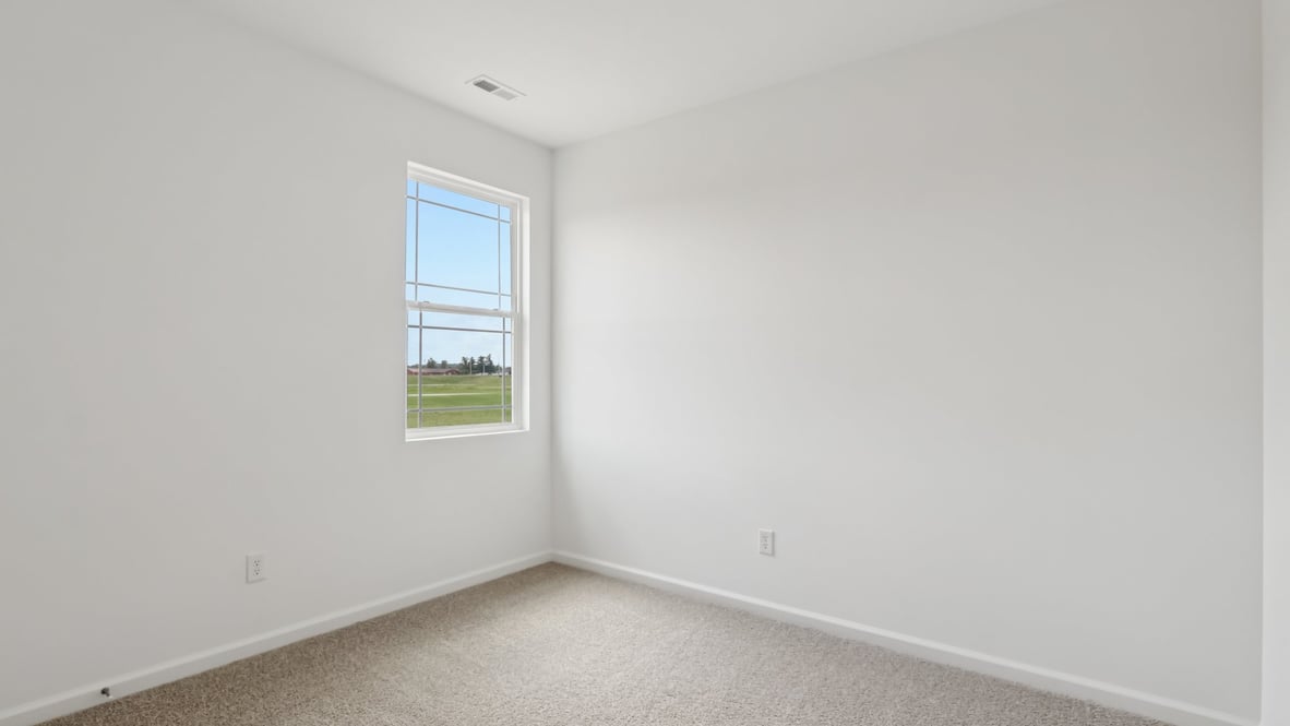 bedroom with brown flooring, white walls and a window