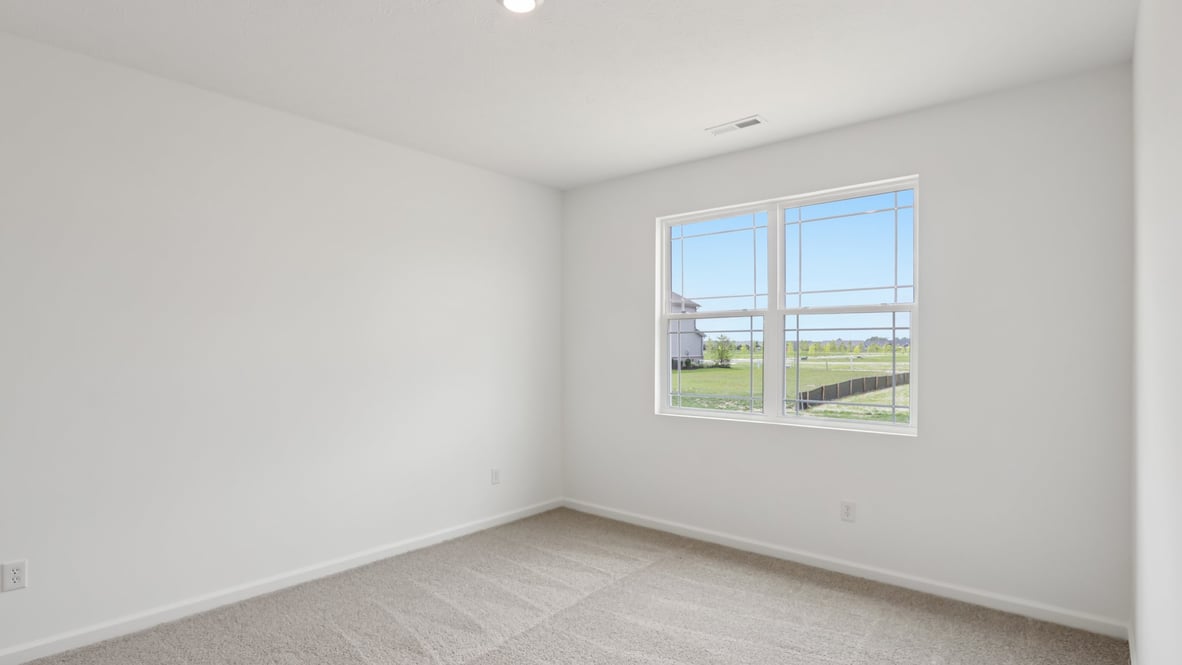 bedroom with brown flooring, white walls and a window