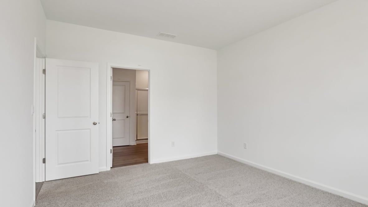 bedroom with brown flooring, white walls
