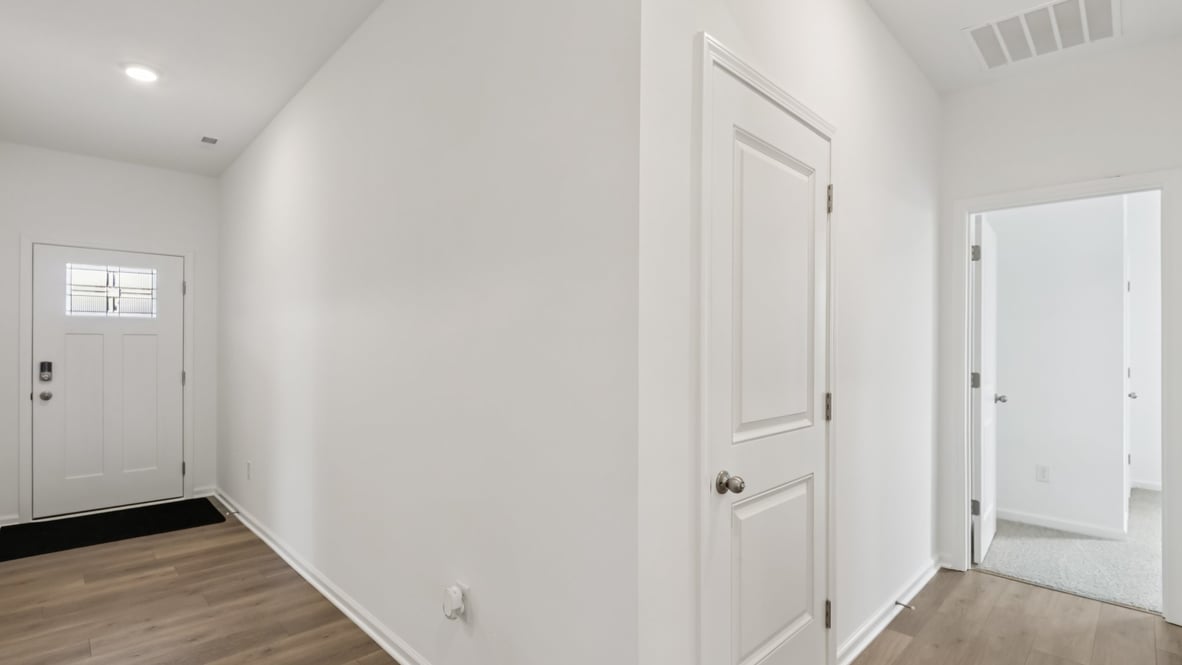 front entry way of home featuring brown flooring and white walls