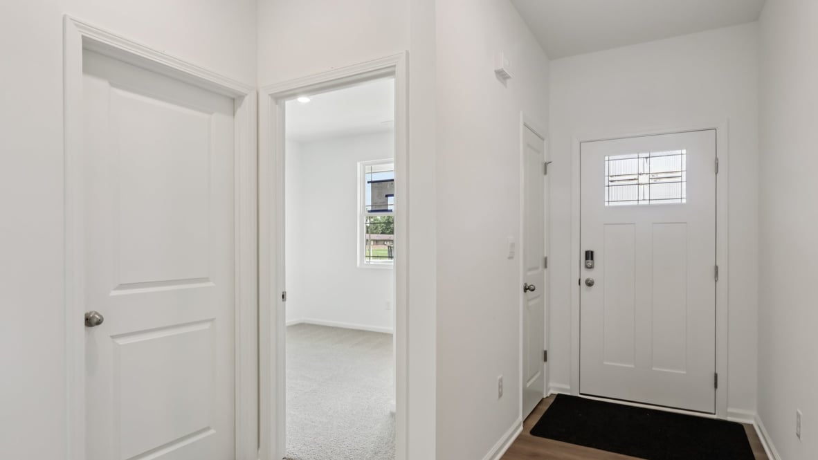 front entry way of home featuring brown flooring and white walls