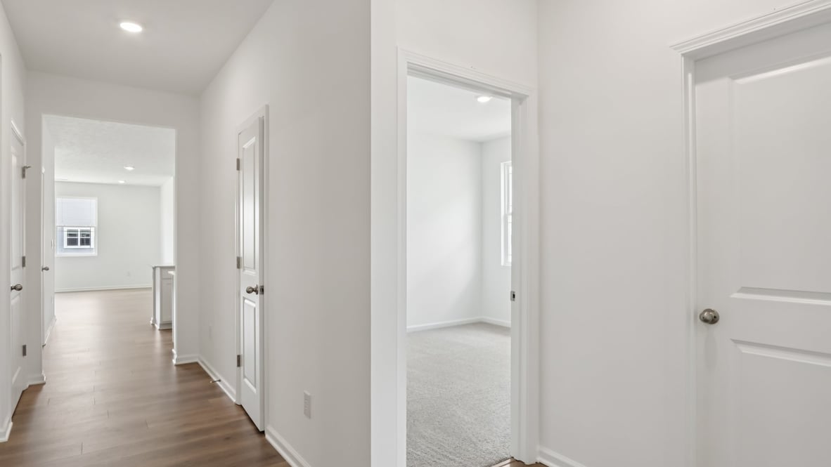 front entry way of home featuring brown flooring and white walls