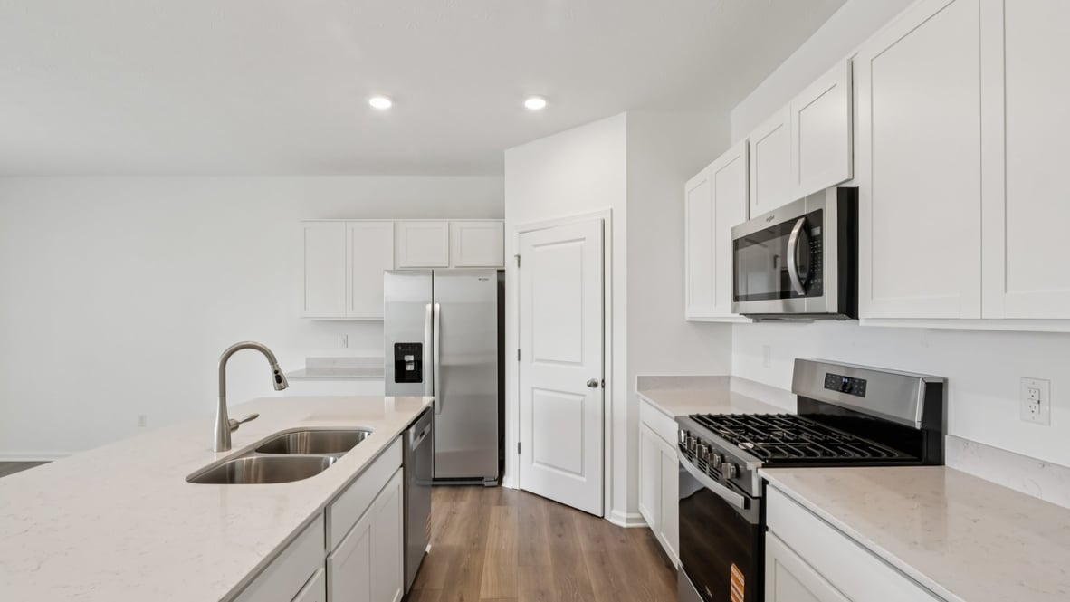 spacious kitchen with white cabinetry, and stainless steel appliances