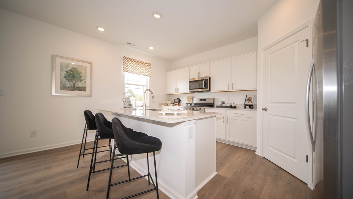 kitchen with white cabinets, island, pantry, and stainless appliances