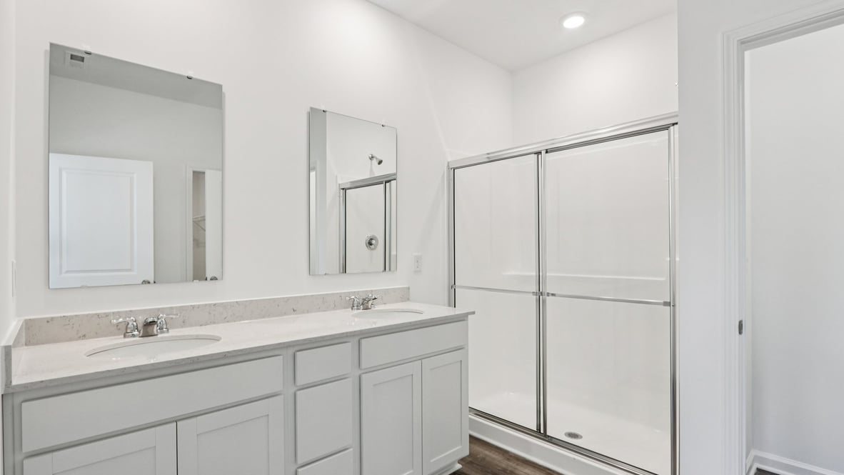 primary bathroom with dual vanity and walk-in shower