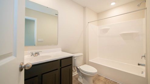 Hall bath with tub shower and nearby linen closet